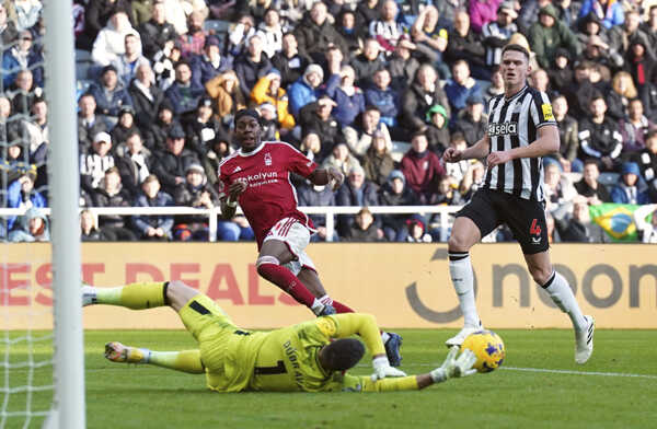 Slovenský brankár Newcastle Martin Dúbravka (na zemi) chytá loptu pred Anthonym Elangom (vľavo).